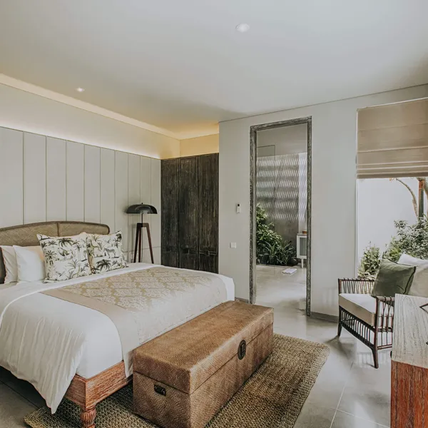 Bedroom with a king bed, carved wooden chest and garden view