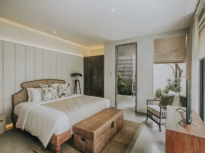 Bedroom with a king bed, carved wooden chest and garden view