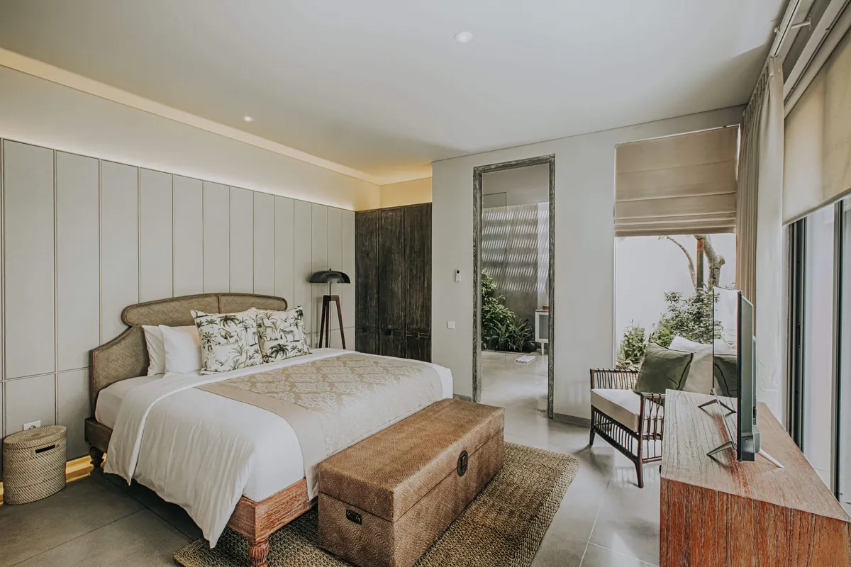 Bedroom with a king bed, carved wooden chest and garden view