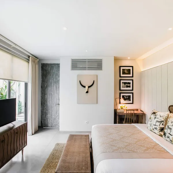Bedroom with artwork, TV and windows onto the garden