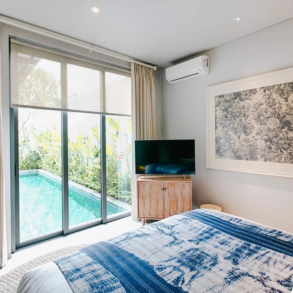 Bedroom with a blue throw and a view of the private pool
