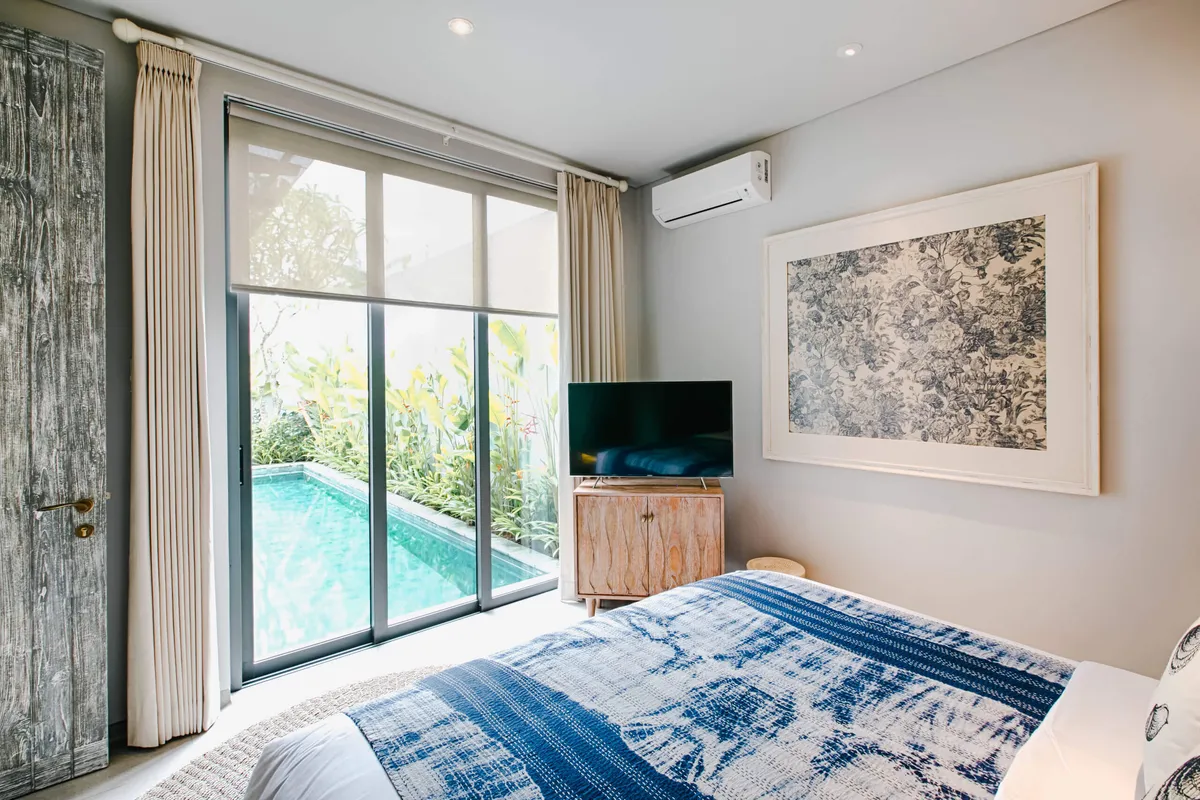 Bedroom with a blue throw and a view of the private pool